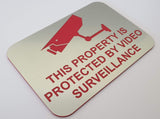 Silver sign with red text and camera icon