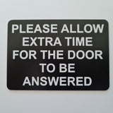 Please Allow Extra Time for the Door to be Answered Sign Plaque in Black Background with White Text