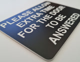 Please Allow Extra Time for the Door to be Answered Sign Plaque in Black Background with White Text