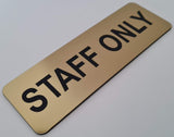 Gold sign with Black 'STAFF ONLY' text on a white background