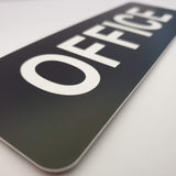 Black sign with 'OFFICE' in white on a light gray background