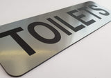Silver sign with Black 'TOILETS' text on a white background