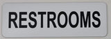 Rectangular White sign with Black text  'RESTROOMS' on a light gray background