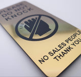 Gold door sign with black text and icon on a white background