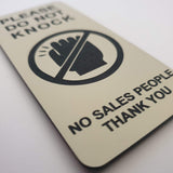 Almond coloured sign with black text and icon on a white background