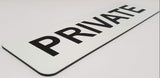 Close-up of a 'PRIVATE' sign on a white surface