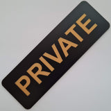 Black sign with 'PRIVATE' in gold on a light gray background
