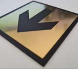 Gold acrylic square sign with a black engraved arrow