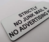 White acrylic sign with black engraved text 'Strictly No Junk Mail & Advertising' on a white background