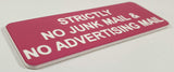 Pink acrylic sign with white engraved text on a white background