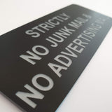 Black acrylic sign with Silver engraved text 'Strictly No Junk Mail & No Advertising' on a white background