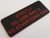 Black acrylic sign with red engraved text on a white background