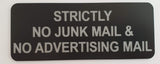 Black acrylic sign with silver engraved  text 'Strictly No Junk Mail & No Advertising Mail' on a light gray background