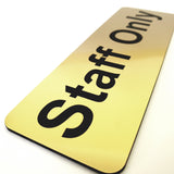 Gold sign with 'Staff Only' in Black text on a white background