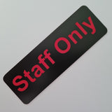 Black sign with red 'Staff Only' text on a gray background