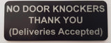 Black sign with silver text on a light gray background
