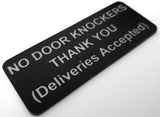 Black sign with silver text on a white background