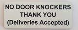 Rectangular sign with text 'NO DOOR KNOCKERS THANK YOU (Deliveries Accepted)' on a white background