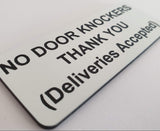 Sign with text 'NO DOOR KNOCKERS THANK YOU (Deliveries Accepted)' on a white background