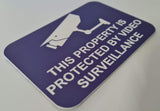 Purple sign with white text and a camera icon, indicating video surveillance.
