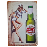 Vintage-style Stella Artois beer bottle with a pin-up girl on a metal sign.