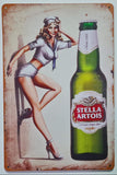 Vintage-style sign featuring a pin-up girl and a Stella Artois beer bottle.