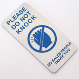 Silver sign with 'Please Do Not Knock' text and blue icon on a white background