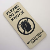 Almond coloured sign with black text and symbol on a white background