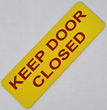 Yellow acrylic sign with red text 'KEEP DOOR CLOSED'