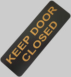 Black acrylic sign with Gold text 'KEEP DOOR CLOSED'