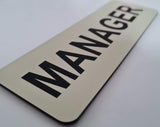 Almond acrylic sign with Black text 'MANAGER'