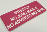 Pink acrylic sign with white engraved text on a light gray background