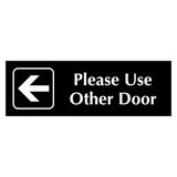 Black acrylic Sign with an arrow pointing left and white engraved text 'Please Use Other Door'
