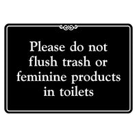 Black sign with white text warning against flushing trash or feminine products in toilets