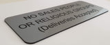 Silver acrylic sign with black engraved text on a white background