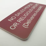 Burgundy acrylic sign with white engraved text on a white background