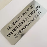 Silver acrylic sign with black engraved text on a white background