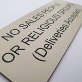 Almond acrylic sign with black engraved text on a white background