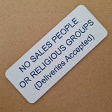 White acrylic sign with blue engraved text on a brown background