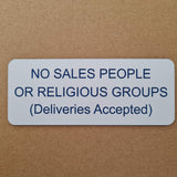 Rectangular white acrylic sign on a brown background with blue engraved text 'NO SALES PEOPLE OR RELIGIOUS GROUPS (Deliveries Accepted)'.