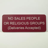 Burgundy acrylic sign with white engraved text on a white background