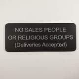 Matte Black acrylic sign with silver engraved text on a light gray background