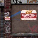 Rustic Carlton Draught sign on a textured wall with graffiti.