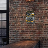 Brick wall with a humorous drinking-themed sign above a wooden table.