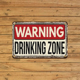 Vintage-style 'WARNING DRINKING ZONE' sign on a wooden background