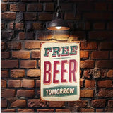 Vintage-style 'Free Beer Tomorrow' sign hanging on a brick wall with a lamp above.