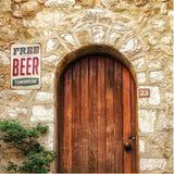 Wooden door on a stone wall with a 'Free Beer Tomorrow' sign above it.